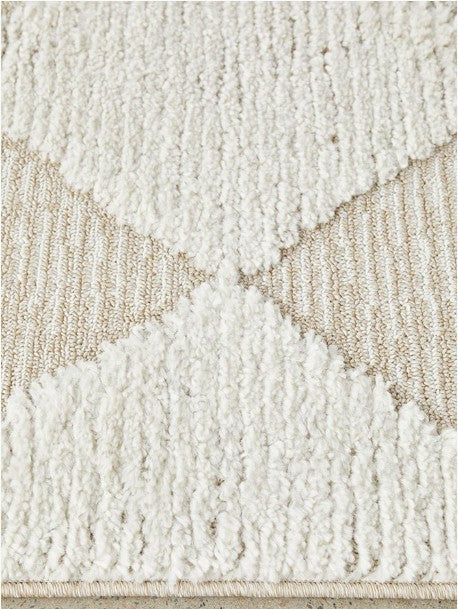 Close-up of a textured beige and white rug with geometric pattern