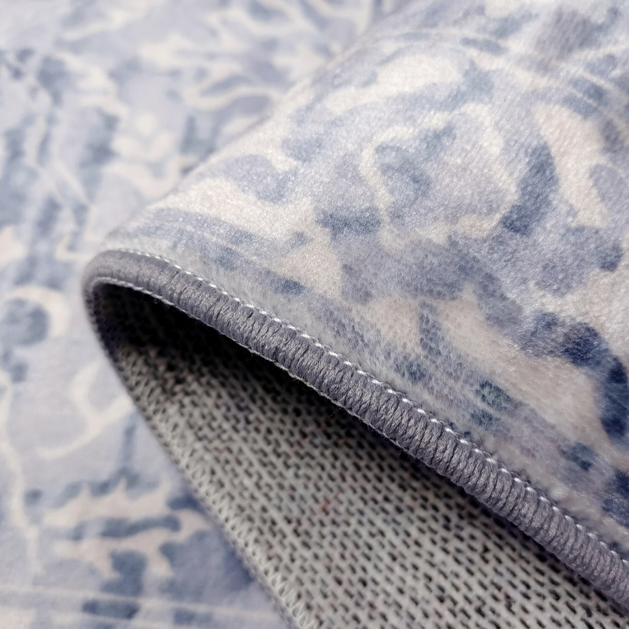 Close-up of a textured blue and white patterned rug with a focus on the edge.