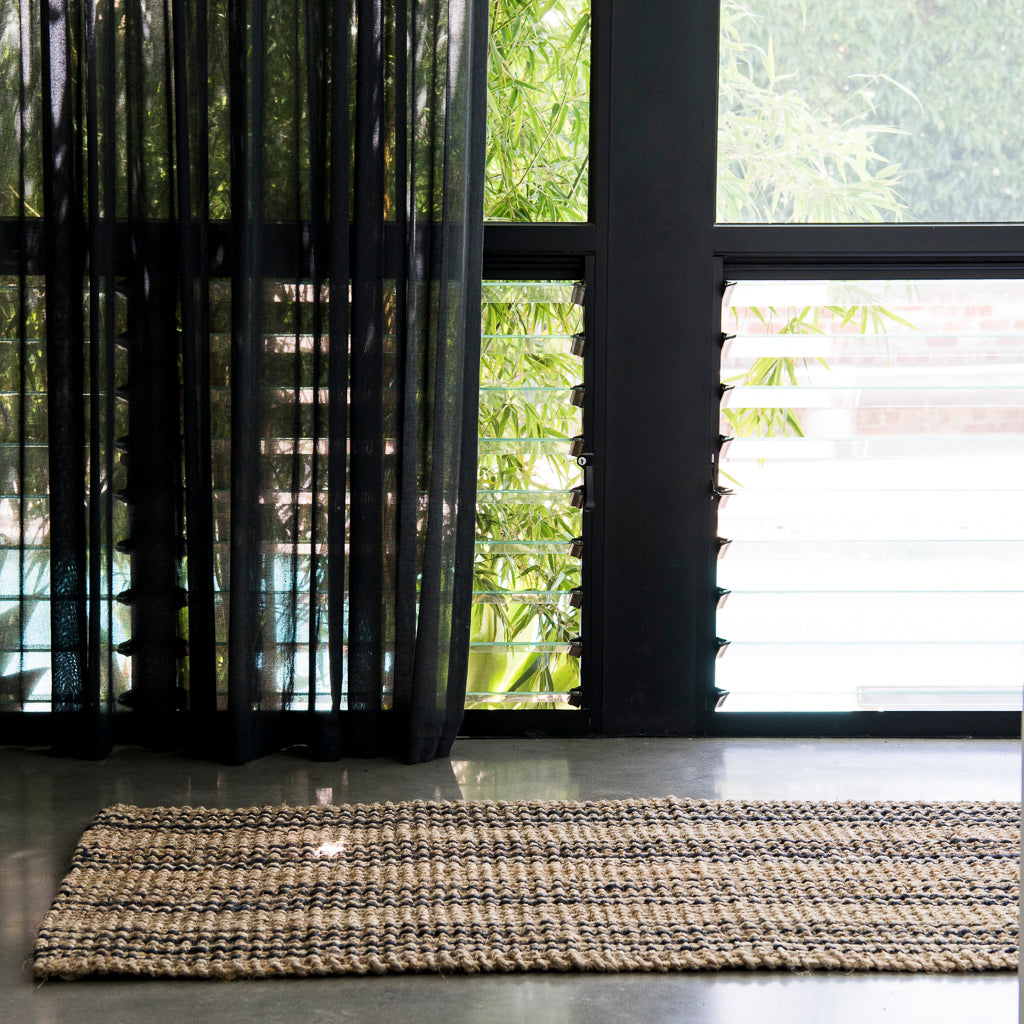 Rug on a floor with glass windows and bamboo in the background