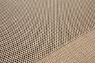 Close-up of a textured beige fabric with a diamond pattern