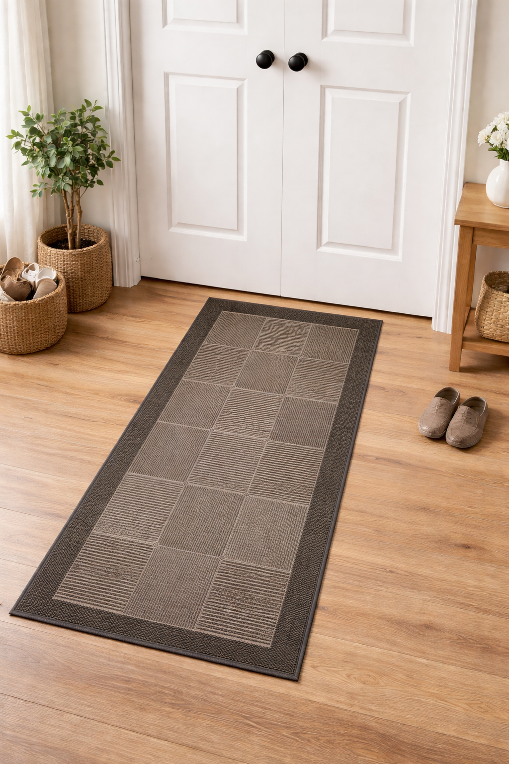 Gray rectangular rug on a wooden floor in a room with white doors and decorative elements.