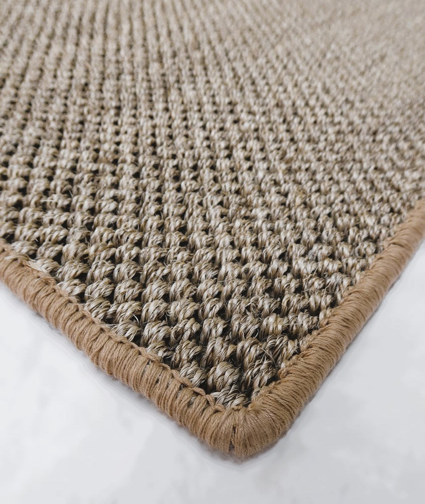 Close-up of a textured beige rug with a white background
