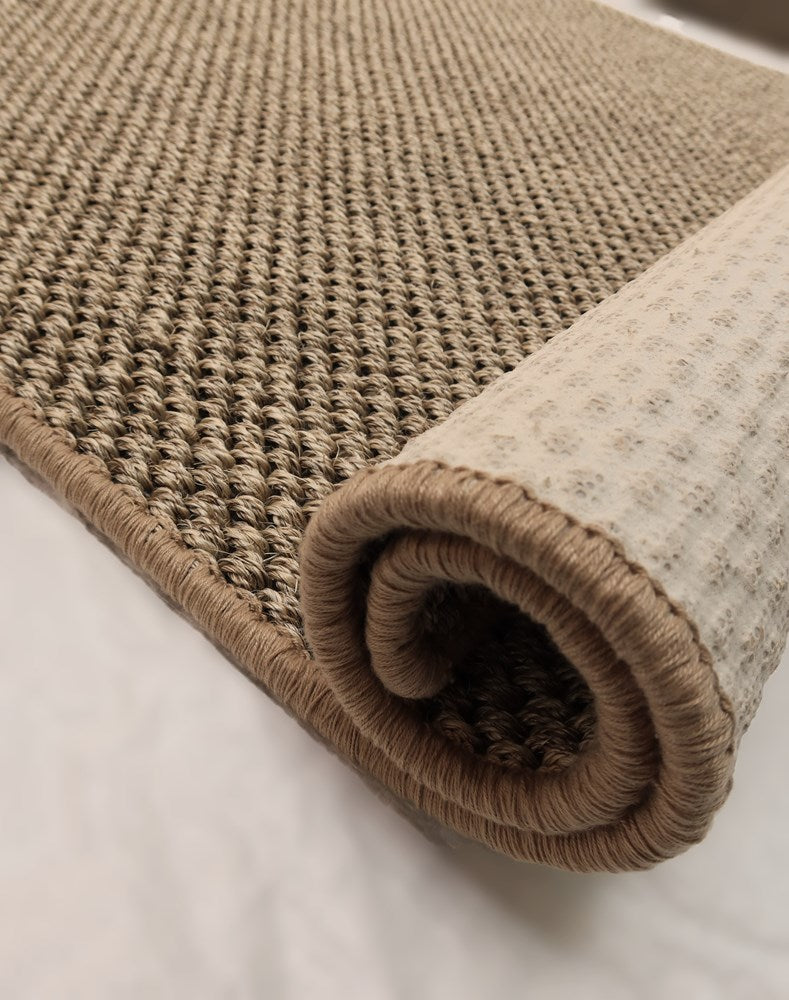 Rolled-up beige carpet on a light background