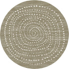 A round area rug with a textured, woven appearance in a warm taupe-beige color, decorated with concentric rings of small white dotted patterns.