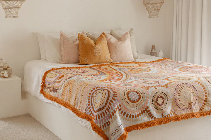 Bed with patterned blanket and pillows in a bedroom setting
