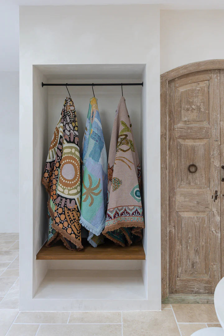 Colorful towels hanging on a rack inside a bathroom with a wooden door.