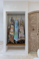 Colorful towels hanging on a rack inside a bathroom with a wooden door.