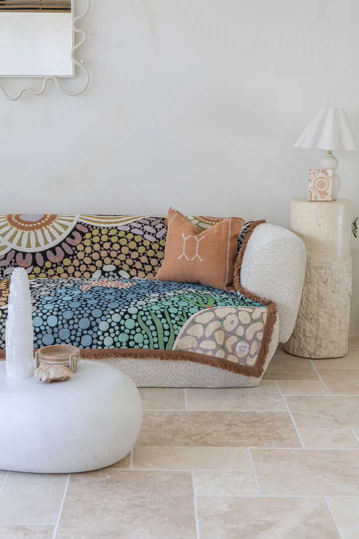 Colorful patterned sofa with decorative pillows in a living room setting.