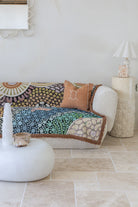 Colorful patterned sofa with decorative pillows in a living room setting.