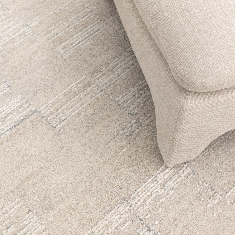 Close-up of a textured beige fabric surface with a sofa corner.
