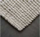 Textured beige rug on a dark surface