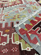 Close-up of patterned rugs with geometric designs in red, gray, and green.