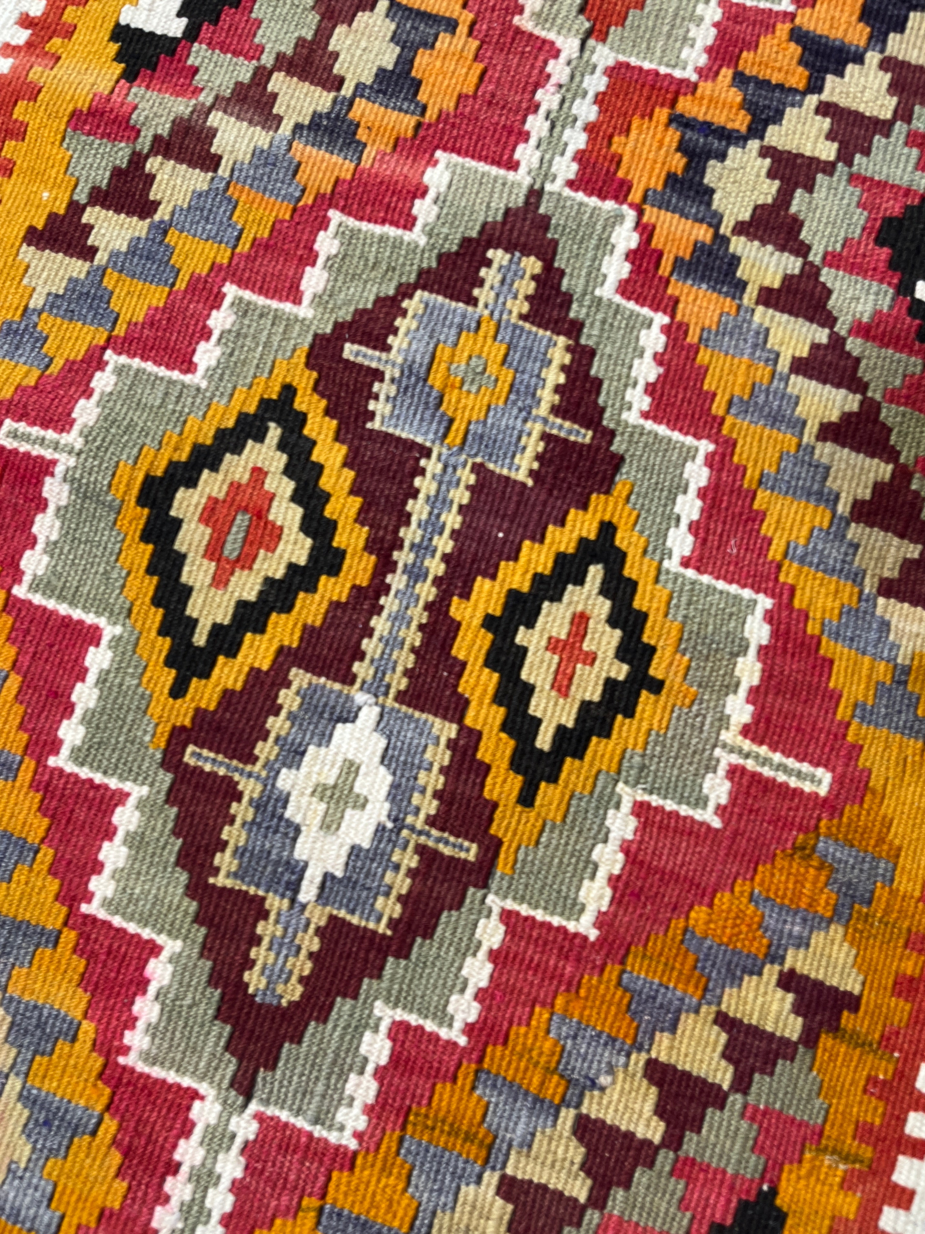 Close-up of a colorful geometric patterned fabric with various colors.