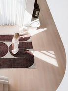 Woman walking on a patterned rug in a modern interior setting