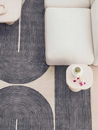 Patterned rug with concentric circles on a neutral-colored floor.