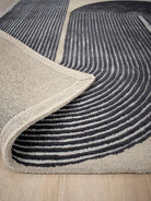 Close-up of a gray and black patterned rug on a wooden floor