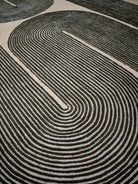 Close-up of a black and white patterned rug with concentric circles.
