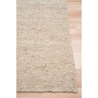 Beige textured rug on a wooden floor