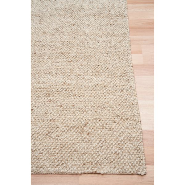 Beige textured rug on a wooden floor