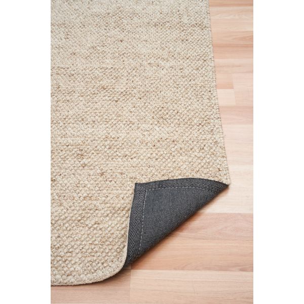 Beige textured rug with dark border on a wooden floor