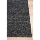 Dark gray textured rug on a light wooden floor