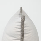 Decorative pillow with textured gray border on a light gray background