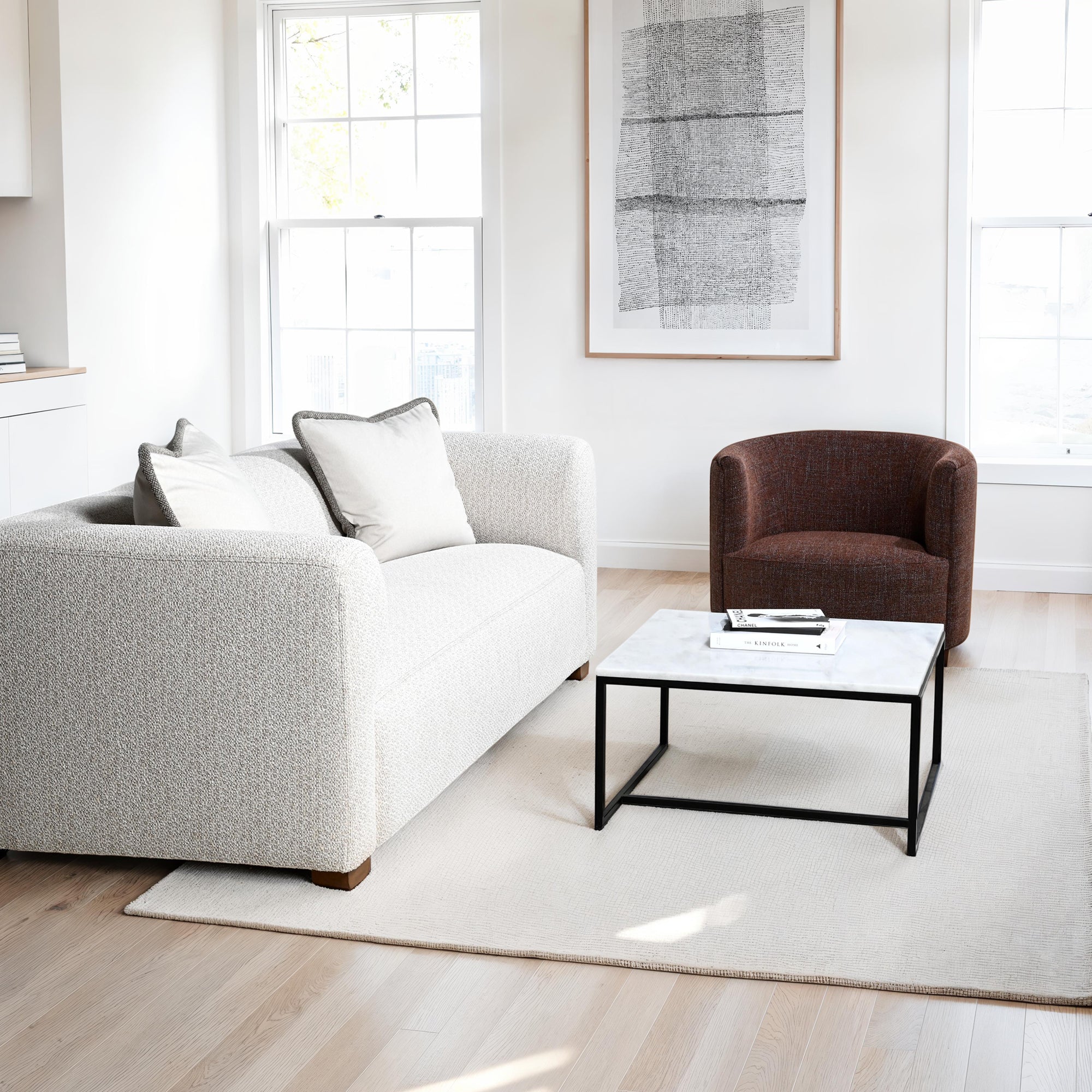 Modern living room with a gray sofa, brown armchair, and white coffee table.