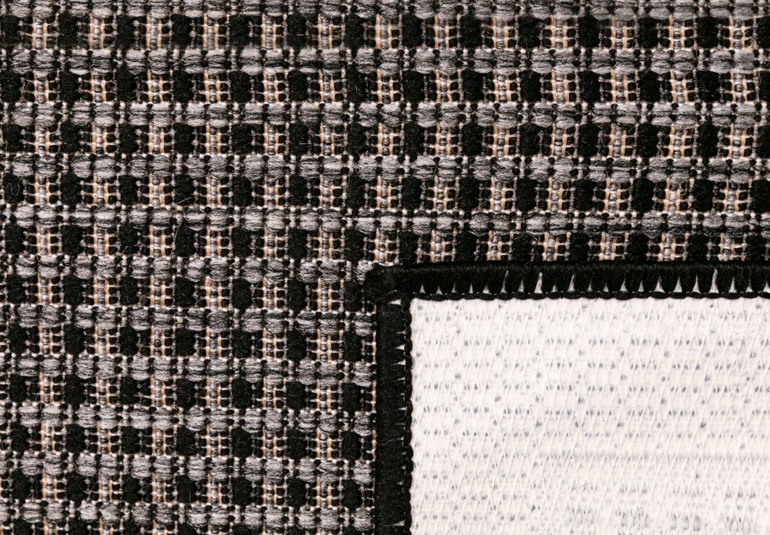 Close-up of a textured fabric with a checkered pattern transitioning to white.