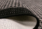 Close-up of textured black and gray rug with geometric pattern