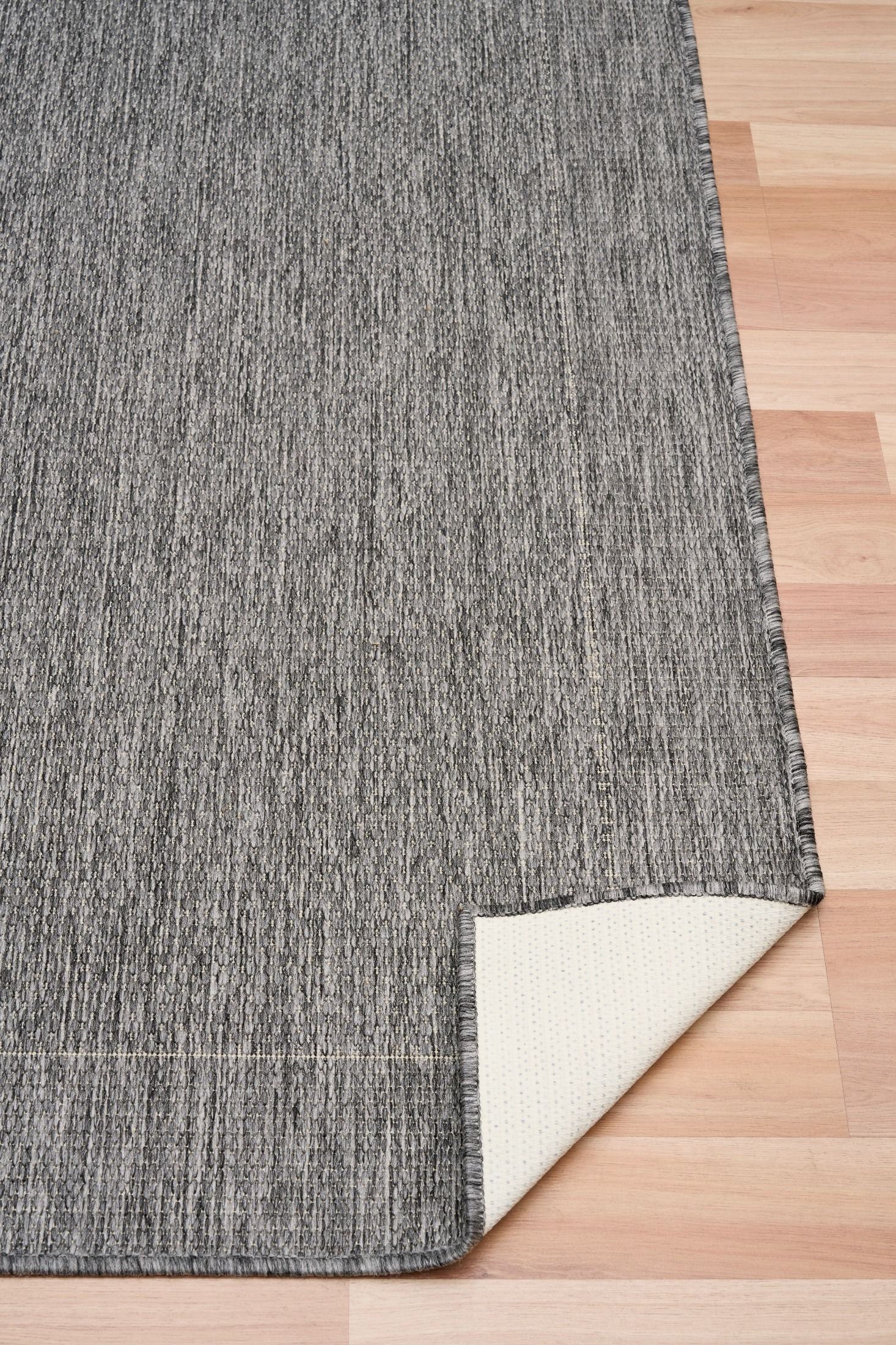 latex backing showing on chino silver white rug laying on timber flooring