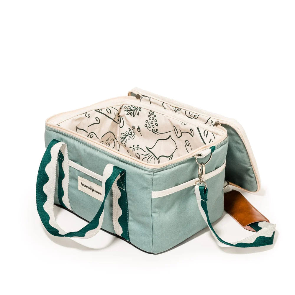 Light blue cooler bag with white interior and green straps on a white background