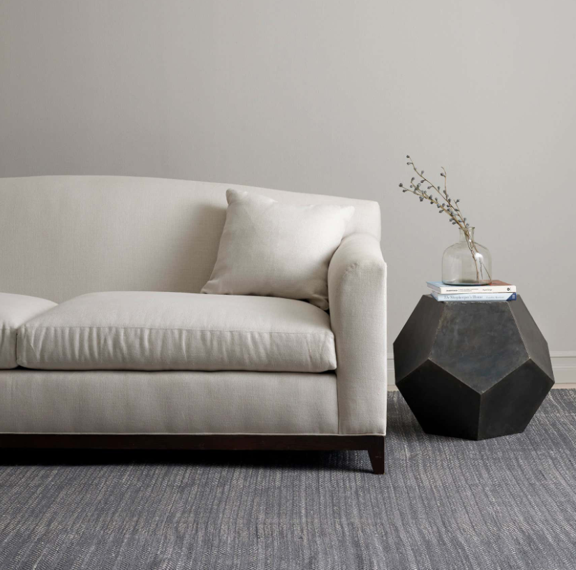 Beige sofa in a room with a geometric side table and minimal decor.