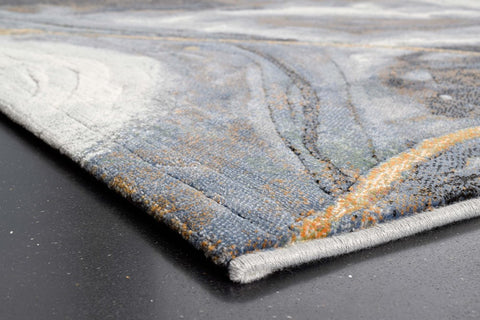 Close-up of a textured rug with gray, blue, and orange colors on a dark surface.