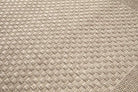 Close-up of a textured beige fabric with a diamond pattern