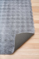 Gray textured rug on a wooden floor