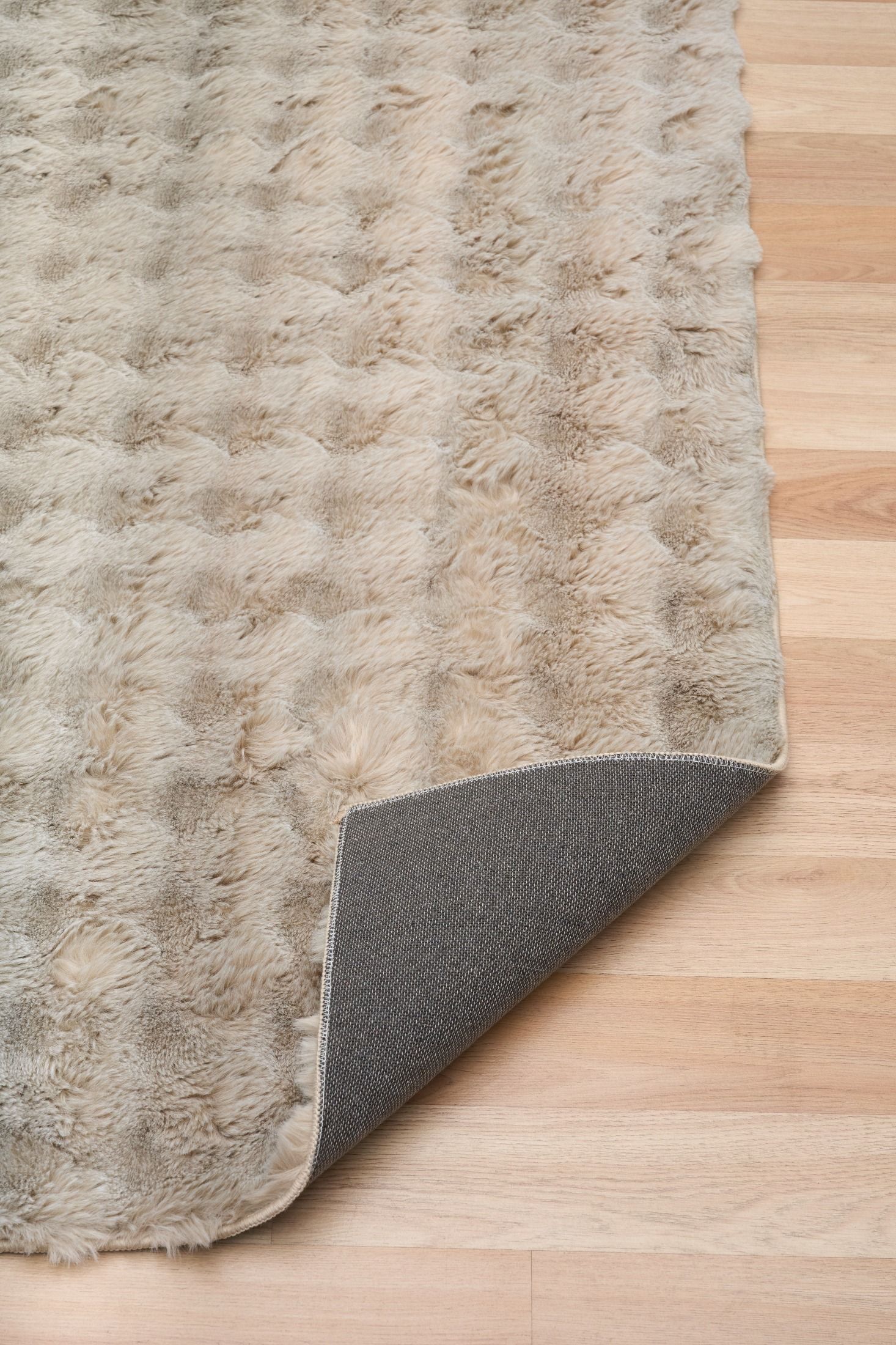 Textured rug with a gray border on a wooden floor
