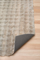 Textured rug with a gray border on a wooden floor