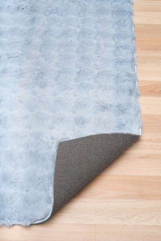 Gray rug corner on a wooden floor