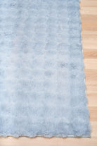 Light blue textured fabric on a wooden surface