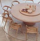 Round wooden dining table with chairs in a room setting