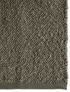 Close-up of a textured area rug showing its looped pile and woven border in a warm taupe-brown color.