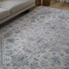 Patterned rug on a wooden floor with a beige sofa in the corner.