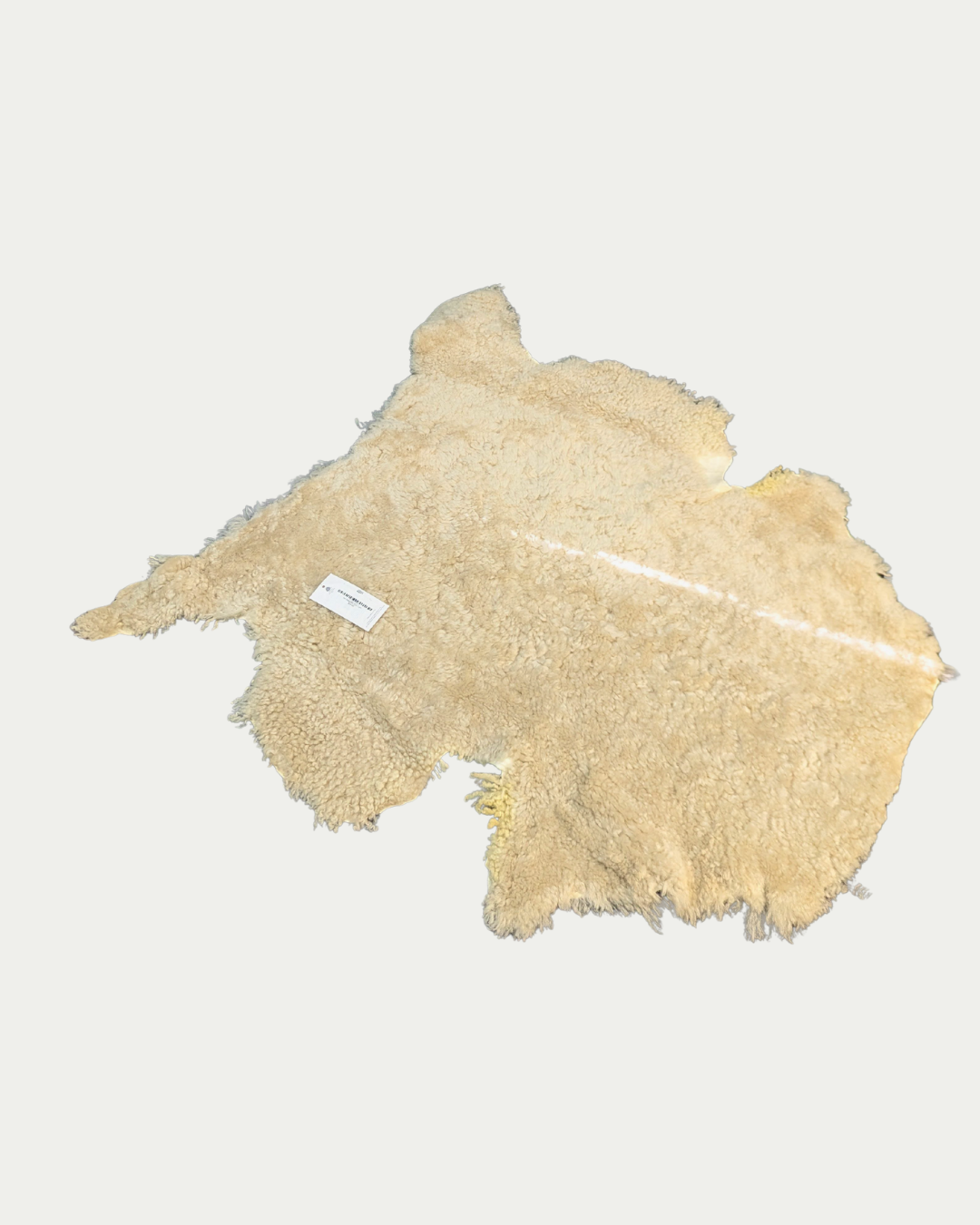 Beige sheepskin rug on a white background