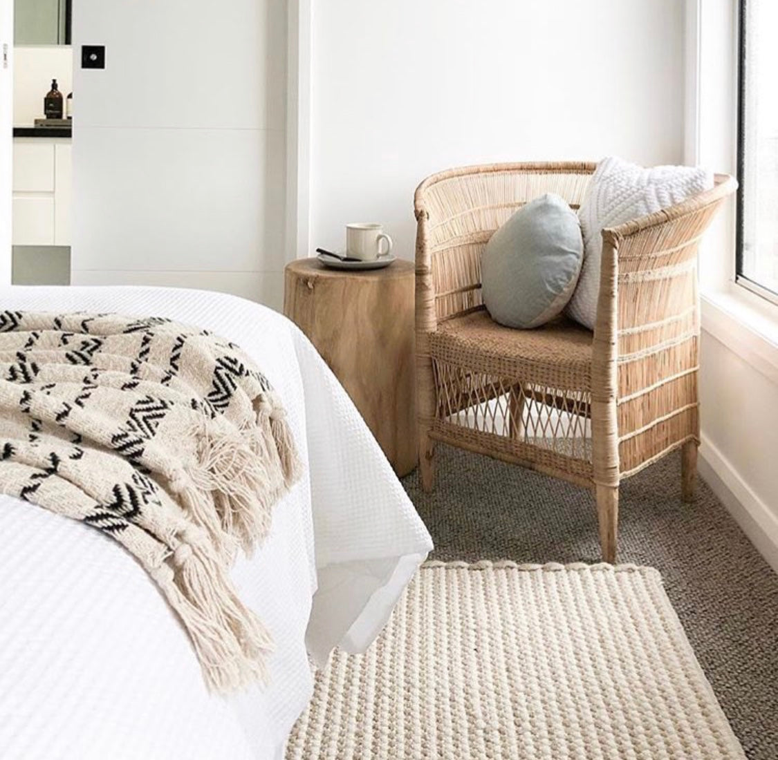 a white rug on a grey carpet floor inside a bedroom