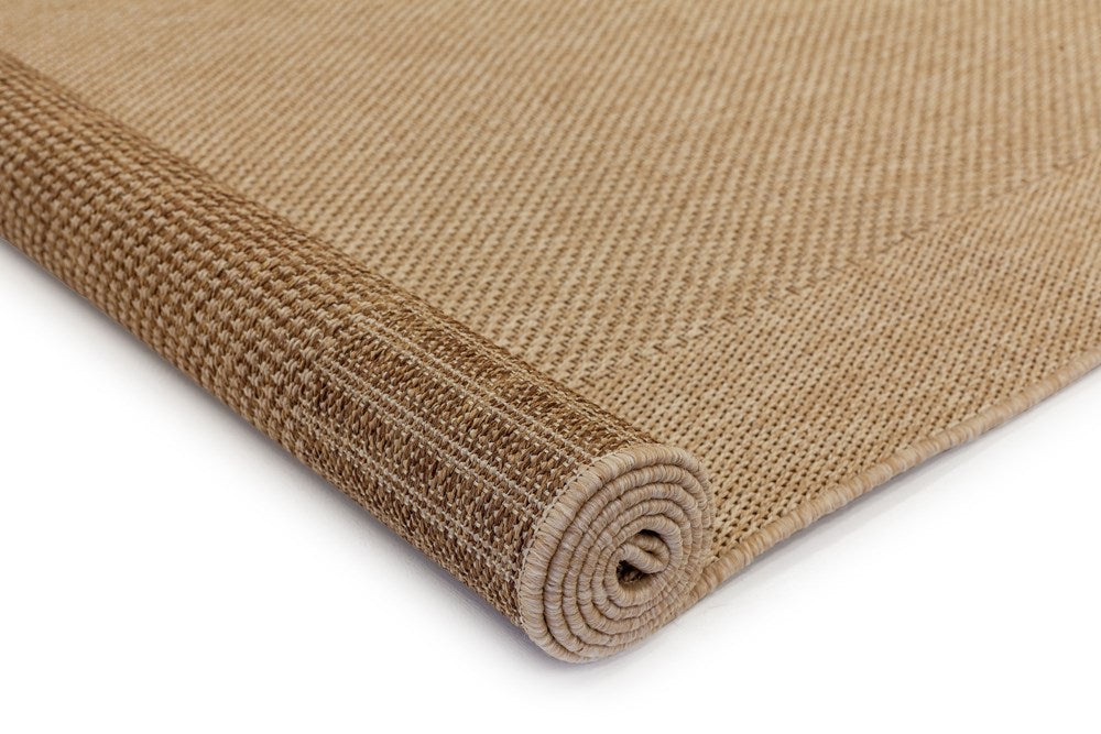 Image of the Noosa Rug's Outdoor Rug in Sand color rolled up, displaying both the top and bottom surfaces, highlighting its flexible and sturdy design suitable for various outdoor settings.
