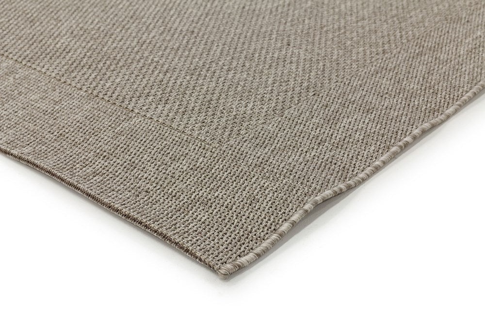 Zoomed-in image of the corner of the Noosa Rug's Outdoor Rug in Washed, highlighting the neat edging and consistent weave of the rug.