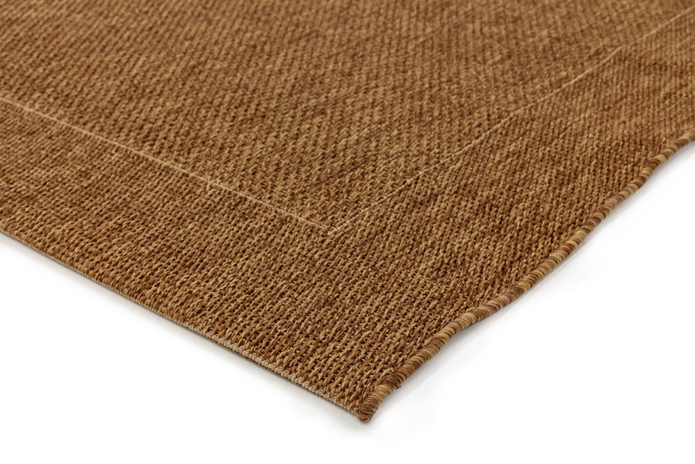 Close-up image focusing on the corner of Noosa Rug's Outdoor Range in Natural, highlighting the meticulous craftsmanship and sturdy edging of the rug.