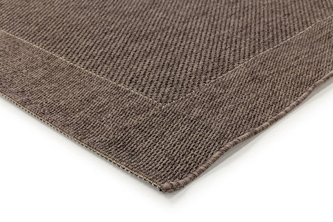 The Noosa Rug's Outdoor Range in Charcoal placed in an outdoor setting, illustrating its waterproof and UV-resistant qualities, perfect for any exterior space.