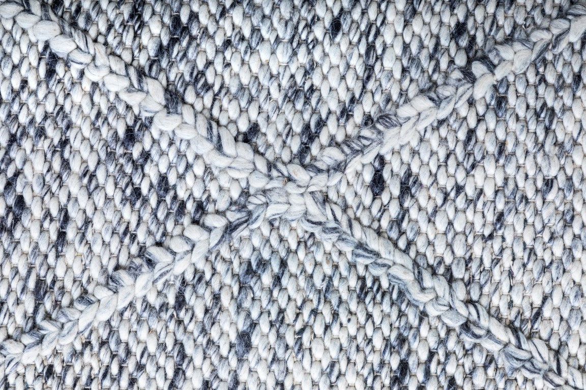 Detailed close-up of the Colombo Grey Rug highlighting the texture, intricate braided diamond pattern, and the quality of the New Zealand wool fibers.