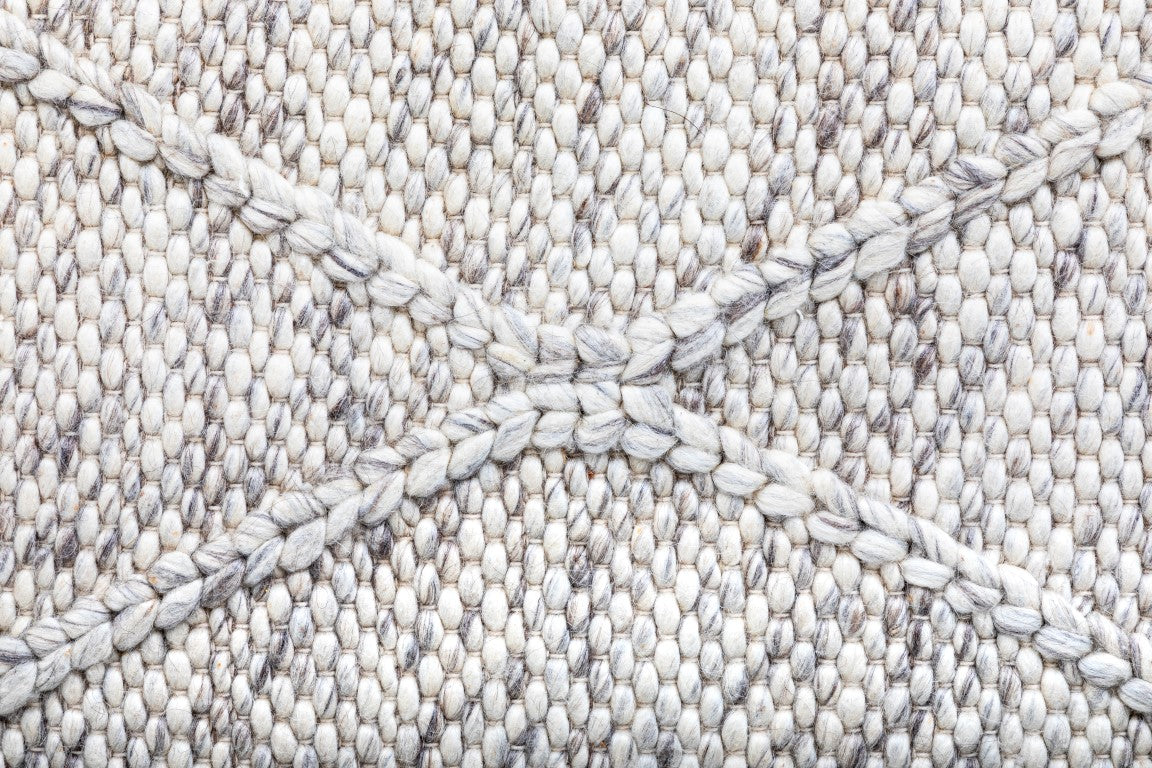 Detailed close-up of the Colombo Light Grey Rug, highlighting the fine texture, quality New Zealand wool fibers, and the subtle intricacies of the braided diamond pattern.